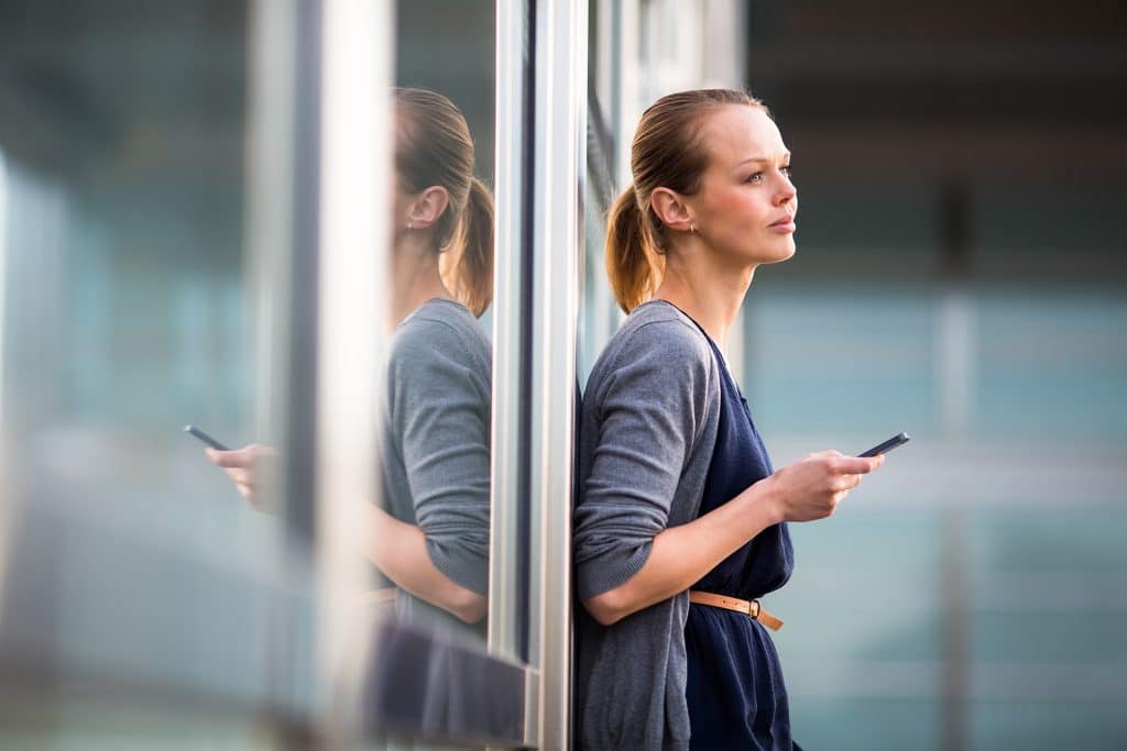 woman holding phone social engineering