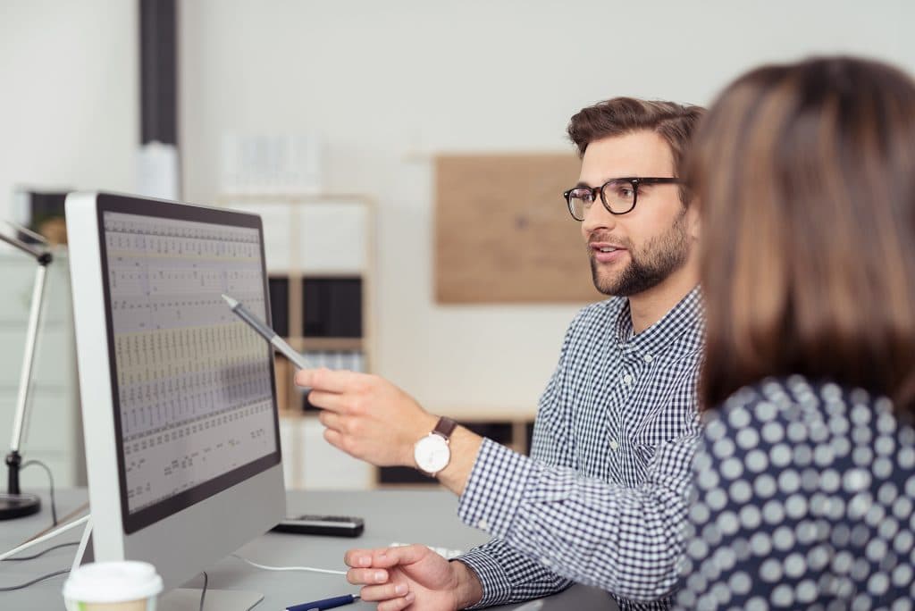 man-pointing-at-screen-showing-data-woman-listening