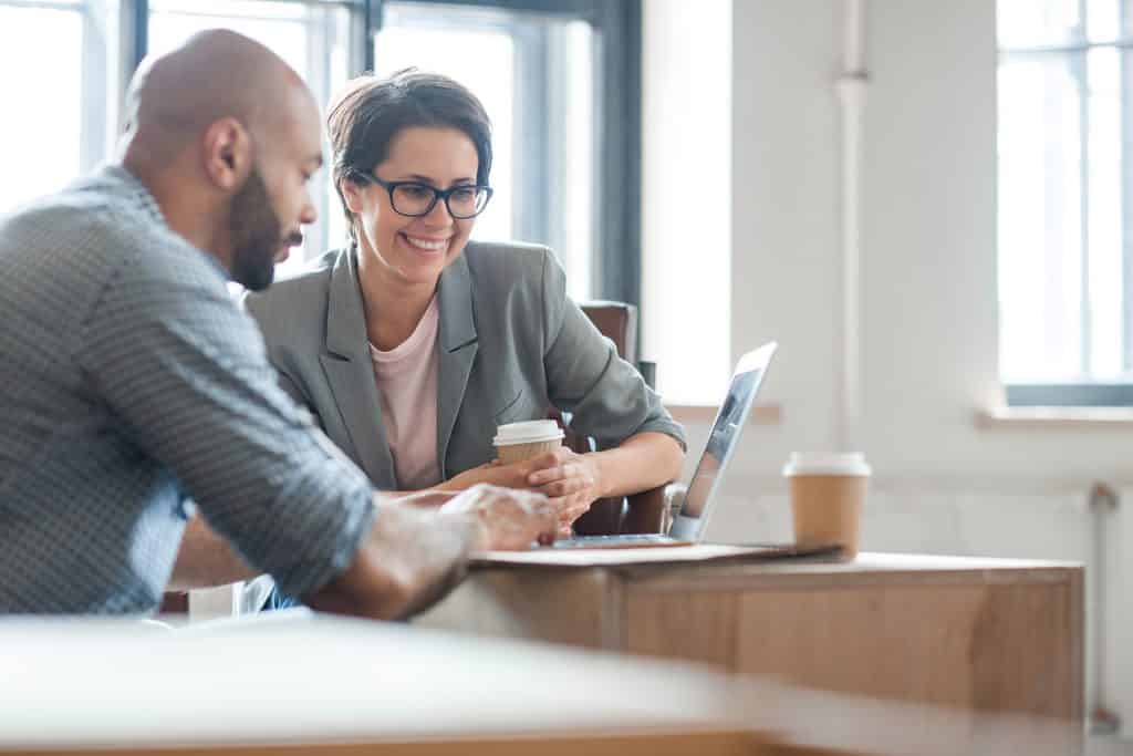 two people working and looking at a screen
