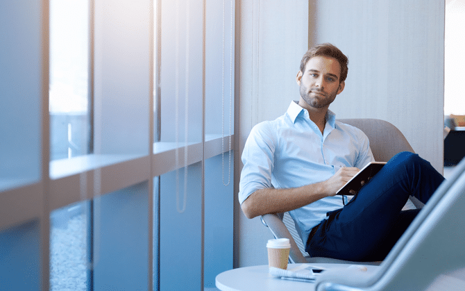 Smartly dressed man, sitting writing on a notepad