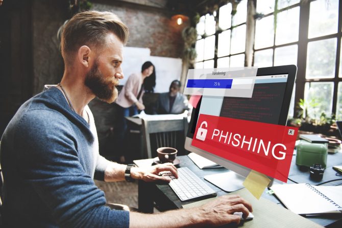 Man at PC experiencing a Phishing Attack