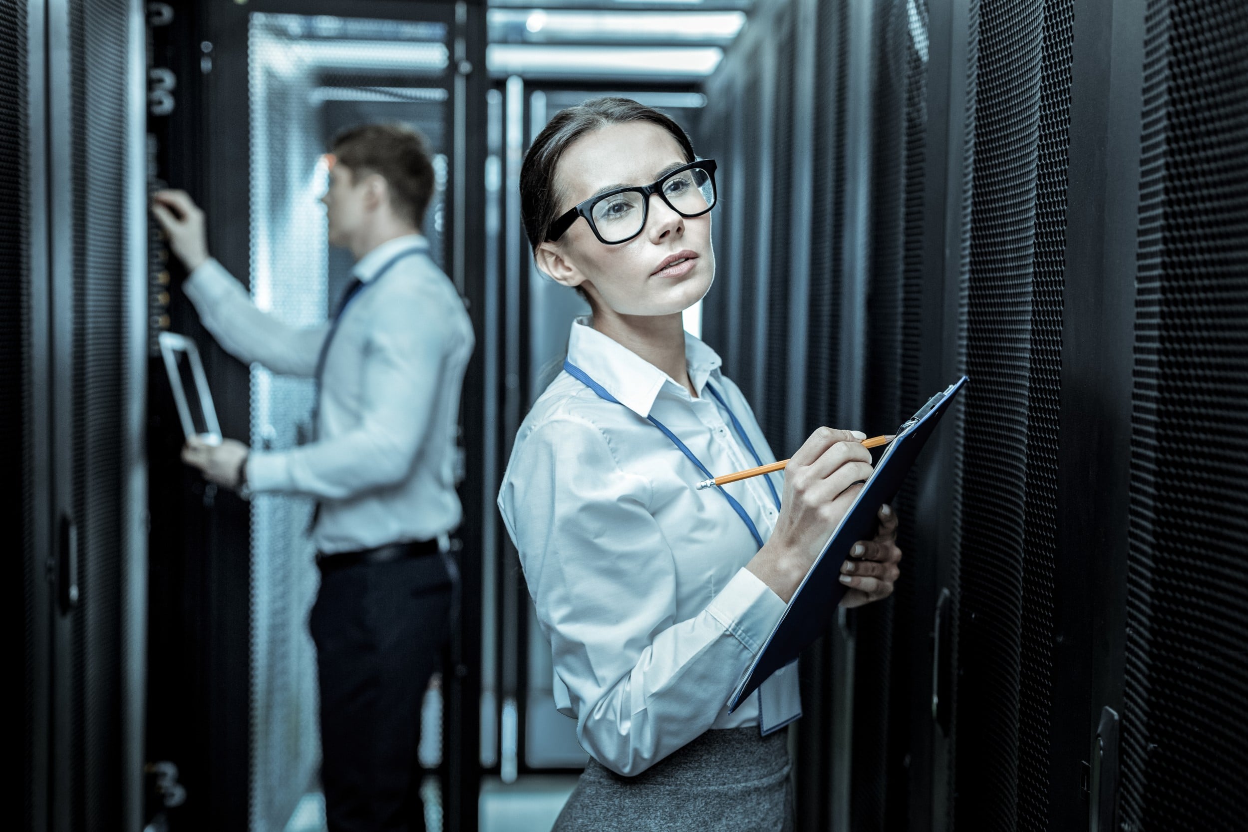 Woman looking at servers holding clipboard